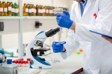 doctor performs blood analysis with microscope