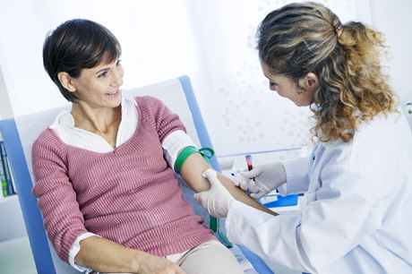 doctor takes blood specimen from a woman