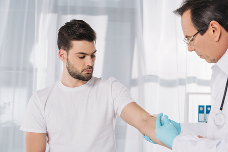 doctor taking patient blood for test in medical gloves