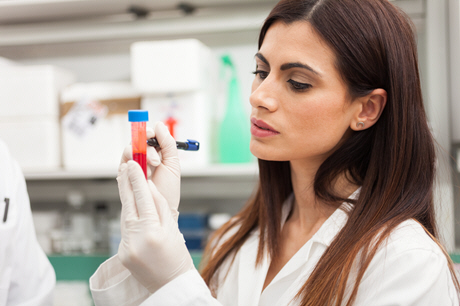 female doctor examines blood sample in lab