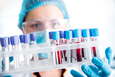 female doctor holding rack of blood samples