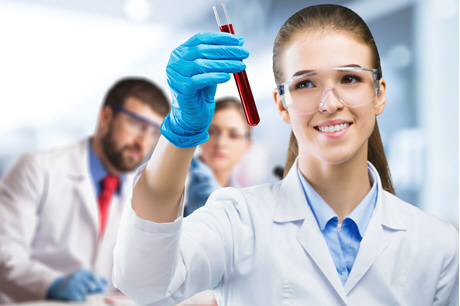female doctor holding tube of blood among staff