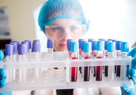 female doctor holds rack of blood samples
