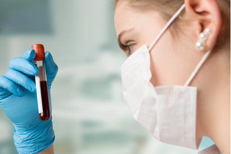 female doctor looking at blood sample close up