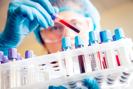 female doctor pulls test tube from rack