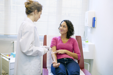 female doctor takes blood sample from female patient