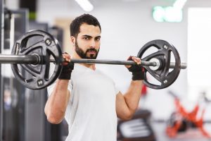 stock photo bearded muscular man wears white t shirt have workout with barbell in the gym 1057888280 300x200