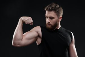 graphicstock fitness man demonstrates bicep looking at bicep in studio isolated dark background_S_2Fav2Snl 300x200